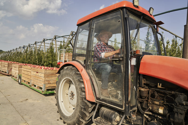 Close-up view of a farm tractor cab, showcasing the interior controls and dashboard in a rural agricultural setting.