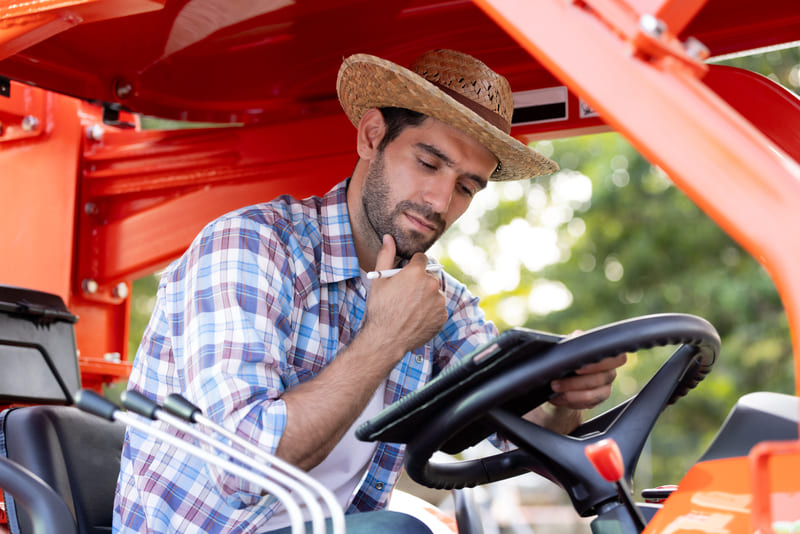 A mechanic performing maintenance on a farm tractor, ensuring optimal performance and longevity of the equipment.