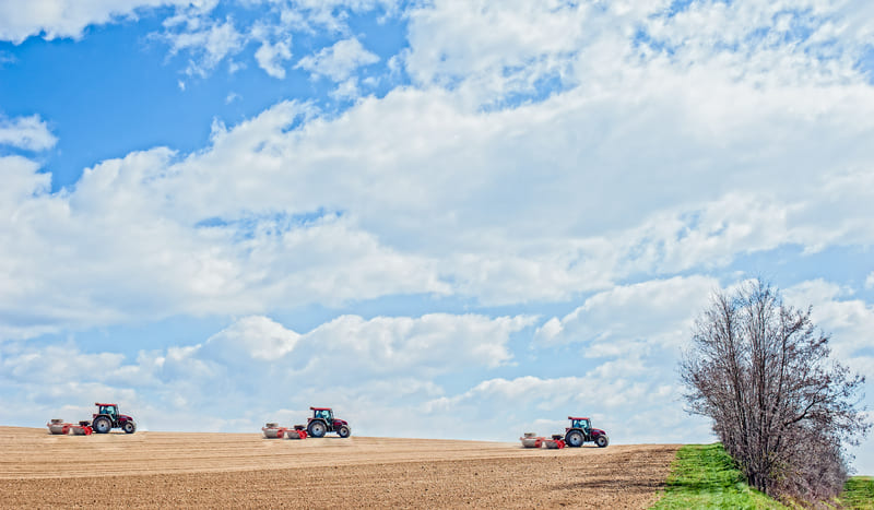 Farm tractors engaged in fieldwork, highlighting the importance of technology in enhancing farming efficiency and output.