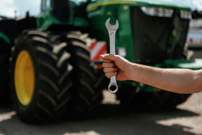 A technician performs maintenance on a tractor's PTO, ensuring optimal performance and safety in agricultural operations.