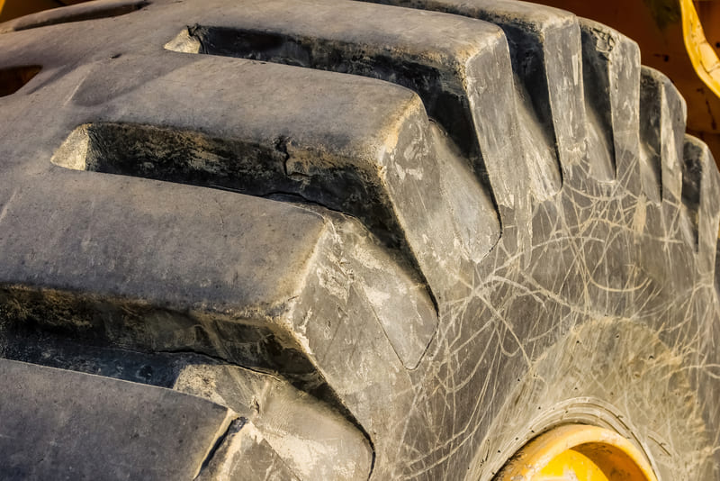Close-up of a tractor wheel showcasing its rugged tread and metallic rim, emphasizing durability and agricultural utility.