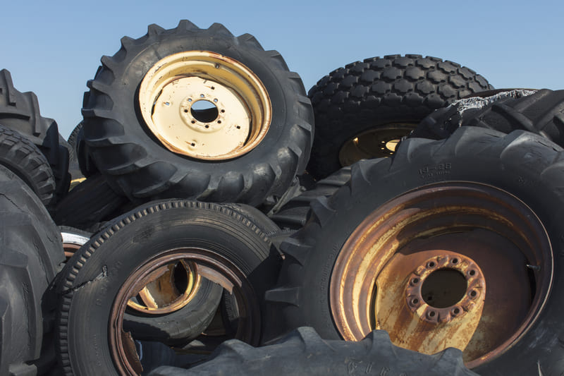 A collection of farm tractor tires of various sizes and tread patterns, stacked for display.