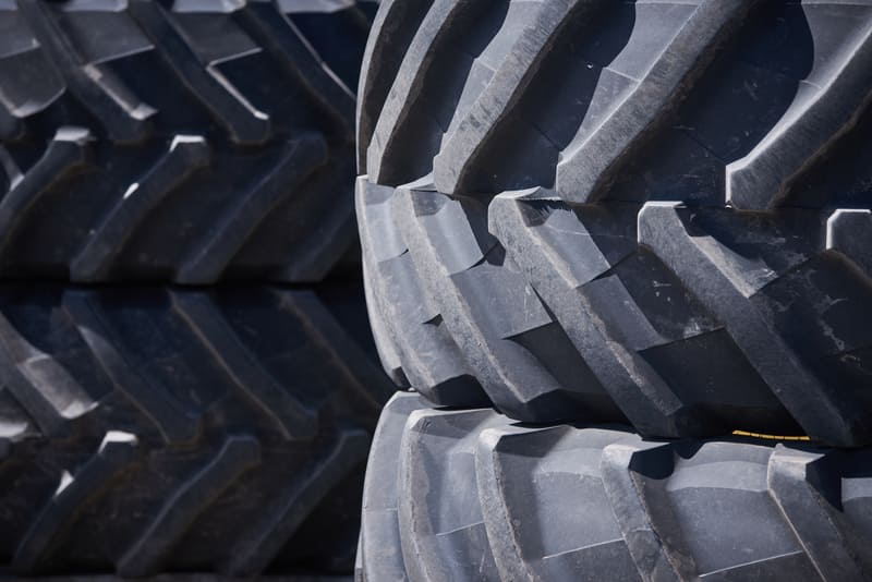 A set of farm tractor tires stored in a dry, covered area to prevent damage and extend their lifespan.