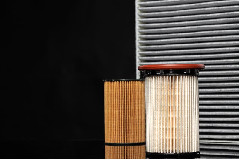 A dirty farm tractor air filter covered in dust and debris, reducing airflow and engine efficiency.