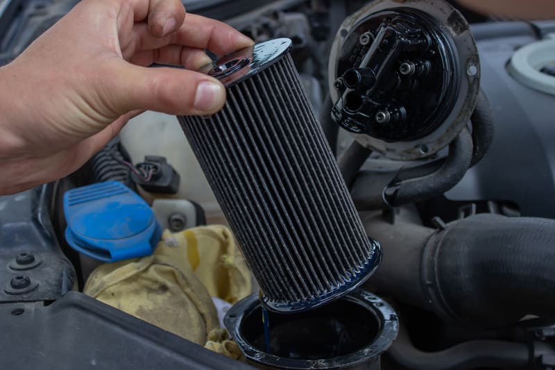 Close-up of a farm tractor air filter showing pleated filter material with visible dust and debris accumulation.