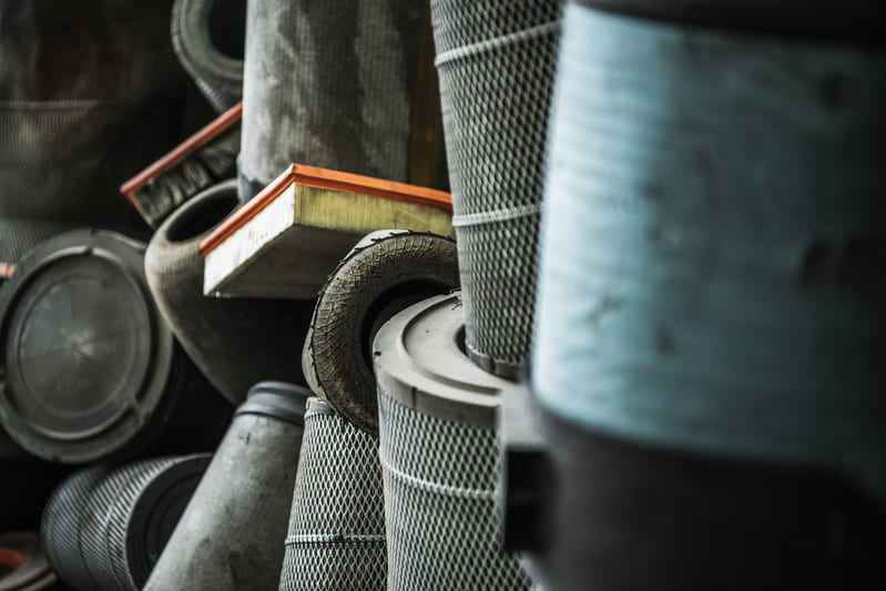 Clean and dirty farm tractor air filters side by side, highlighting the importance of regular maintenance for optimal engine performance.