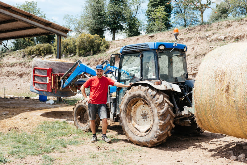 A well-maintained farm tractor stored inside a clean, dry shed, protected from weather and environmental damage.