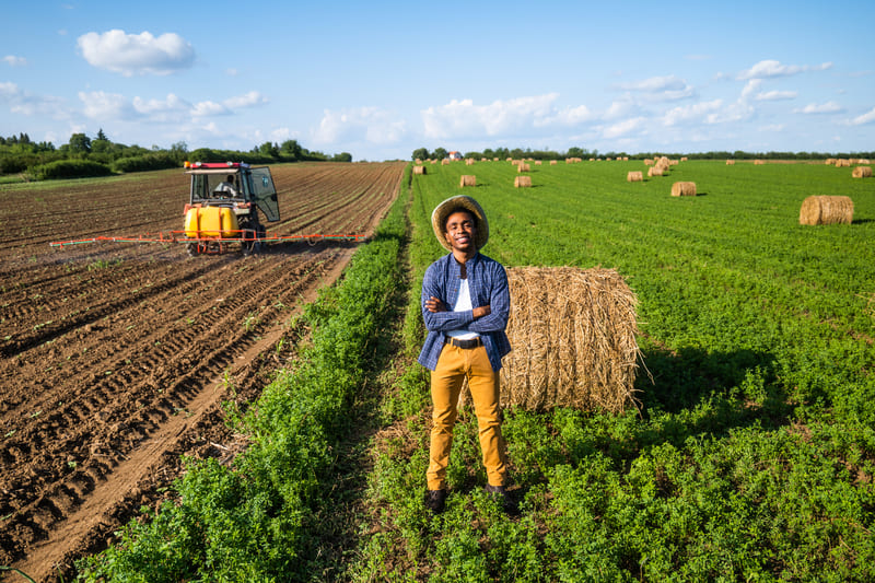 A new tractor working in a crop field, towing modern implements with precision, showcasing its role in improving efficiency and productivity.