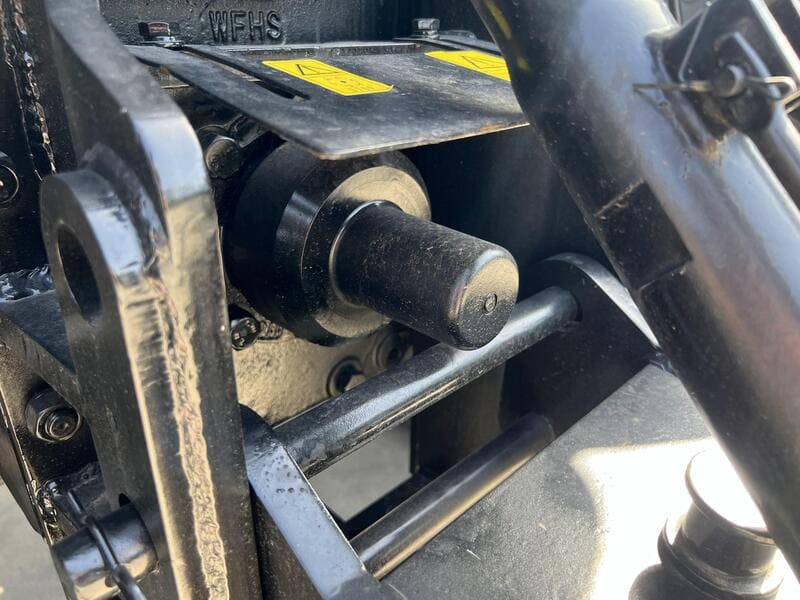 Close-up of a farm tractor’s PTO (Power Take-Off) shaft connected to a rear implement, transferring engine power for efficient operation.