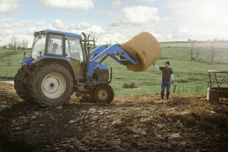 A compact tractor maneuvering between rows in a narrow orchard, showcasing agility and control in tight agricultural spaces.