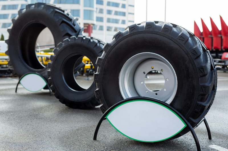 Close-up of durable farm tractor tires showing deep treads and rugged texture for agricultural use.