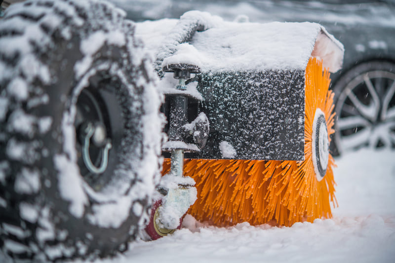Winter tractor equipped with heavy-duty tires driving through snow on a farm, offering enhanced traction.